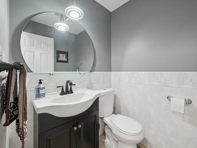 a bathroom with a toilet a sink a mirror and vanity