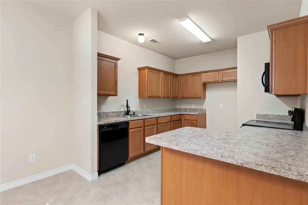 1119 East Epstein Street Sherman, TX 75090 - Photo 5 of 13 a kitchen with granite countertop a sink and a stove top oven