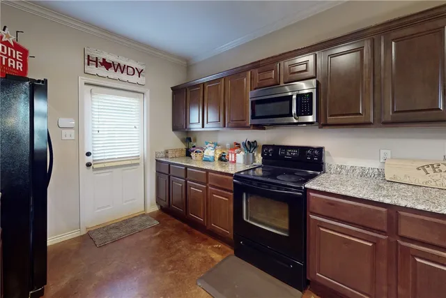 a kitchen with stainless steel appliances granite countertop a refrigerator stove and microwave