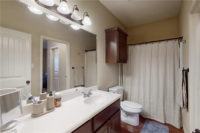 a bathroom with a toilet a sink and mirror