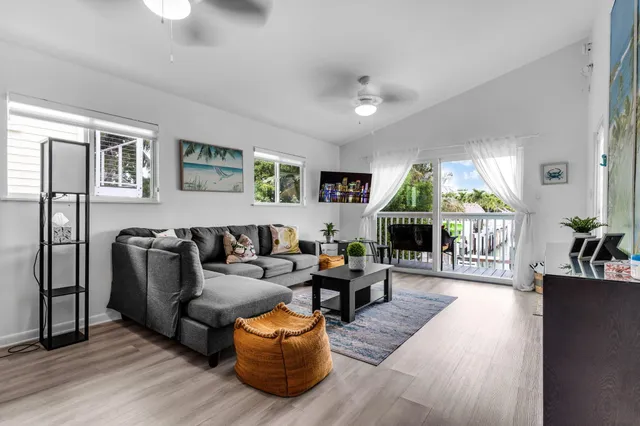 a living room with furniture kitchen view and a window
