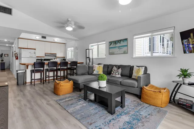 a kitchen with stainless steel appliances a microwave a stove a refrigerator a table and chairs