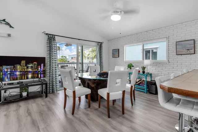 a kitchen with stainless steel appliances granite countertop a table chairs refrigerator and sink