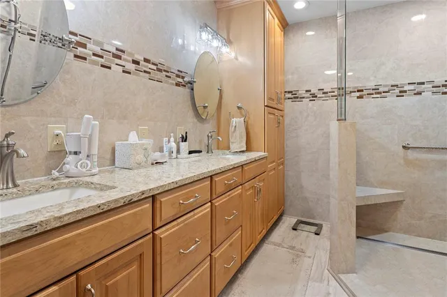 a bathroom with a granite countertop sink toilet and shower