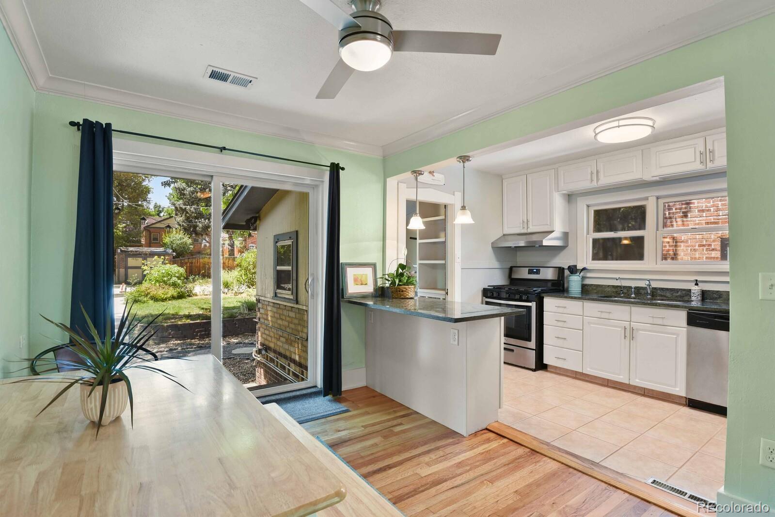 3615 Lowell Boulevard Denver, CO 80211 - Photo 6 of 23 a kitchen with stainless steel appliances granite countertop a stove top oven a sink dishwasher a dining table and chairs with wooden floor