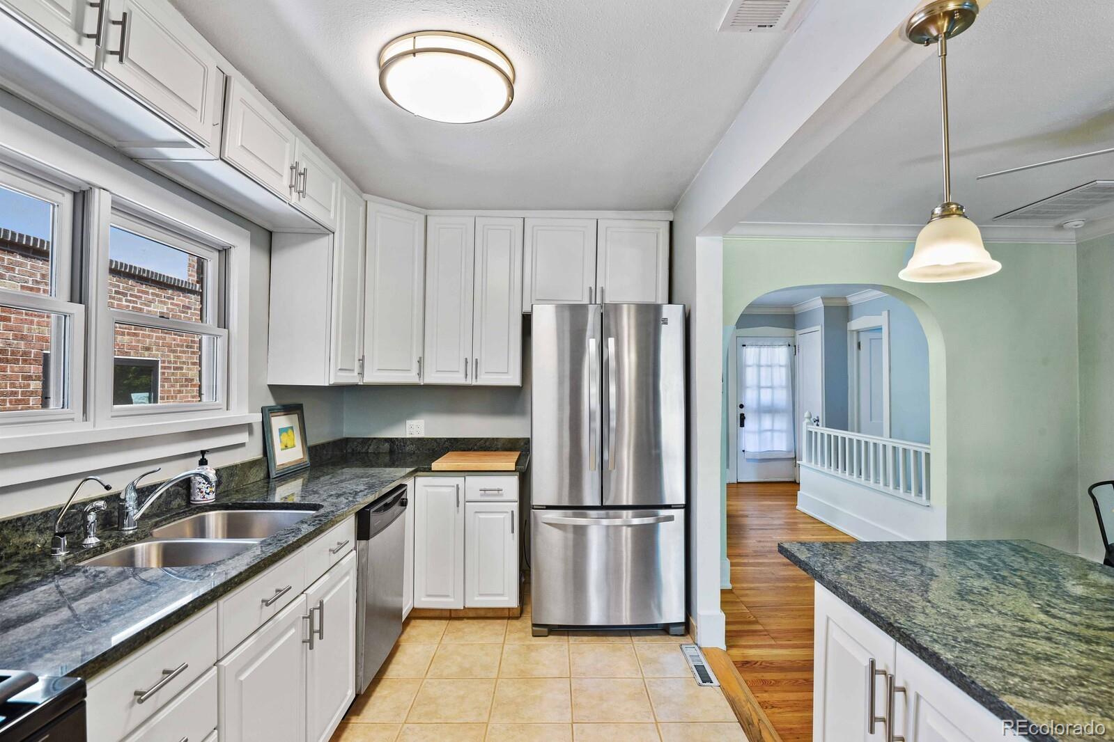 3615 Lowell Boulevard Denver, CO 80211 - Photo 8 of 23 a kitchen with stainless steel appliances granite countertop a stove a refrigerator and a sink