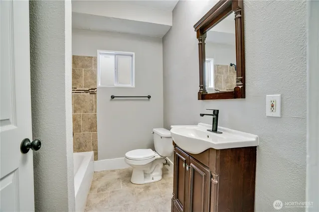 a bathroom with a sink a toilet and mirror