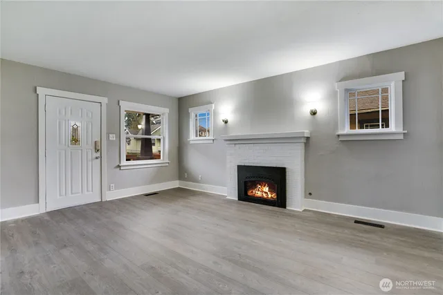 a view of an empty room with a window and fireplace