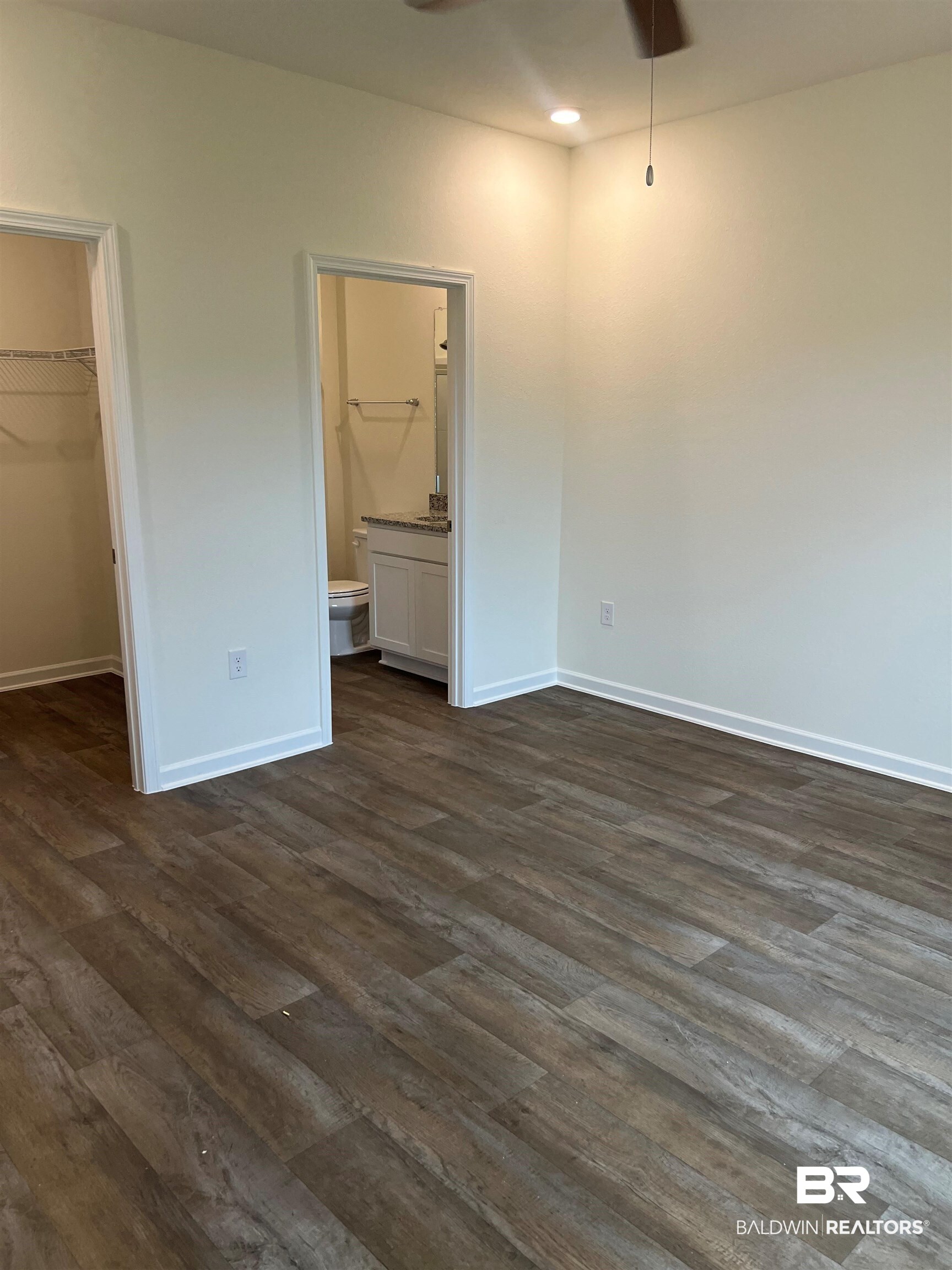 12829 Patriot Way Daphne, AL 36527 - Photo 25 of 38 Unfurnished bedroom featuring dark hardwood / wood-style floors, ensuite bath, a closet, and a walk in closet