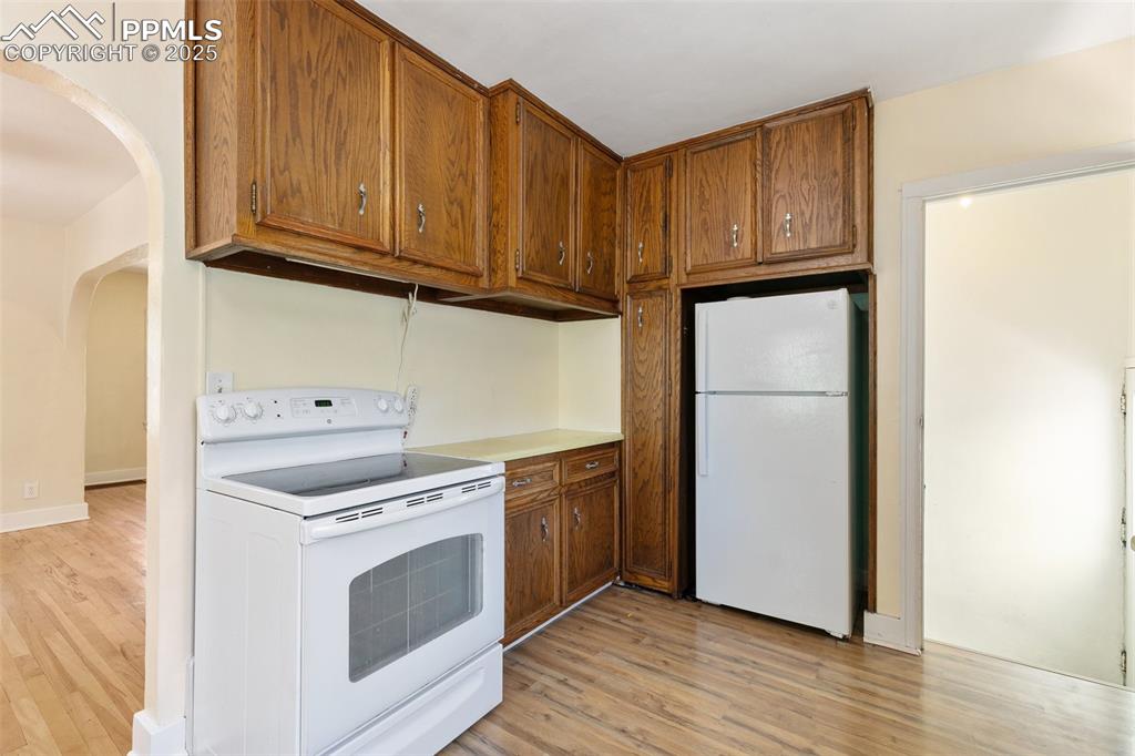 623 Swope Avenue Colorado Springs, CO 80909 - Photo 15 of 39 a kitchen with wooden cabinets and a stove top oven