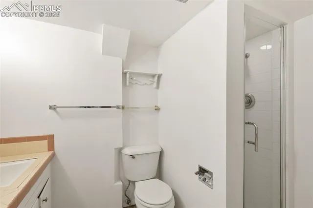 a bathroom with a toilet and a shower