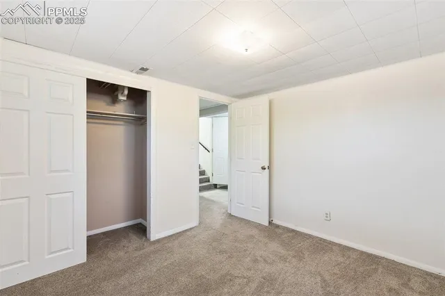 an empty room with closet and wooden door