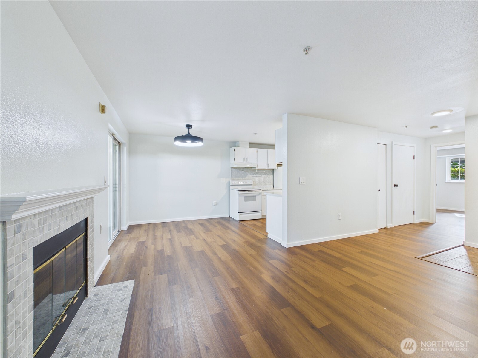 11002 Southeast Petrovitsky Road, Unit I102 Renton, WA 98055 - Photo 5 of 24 a view of empty room with wooden floor and fireplace