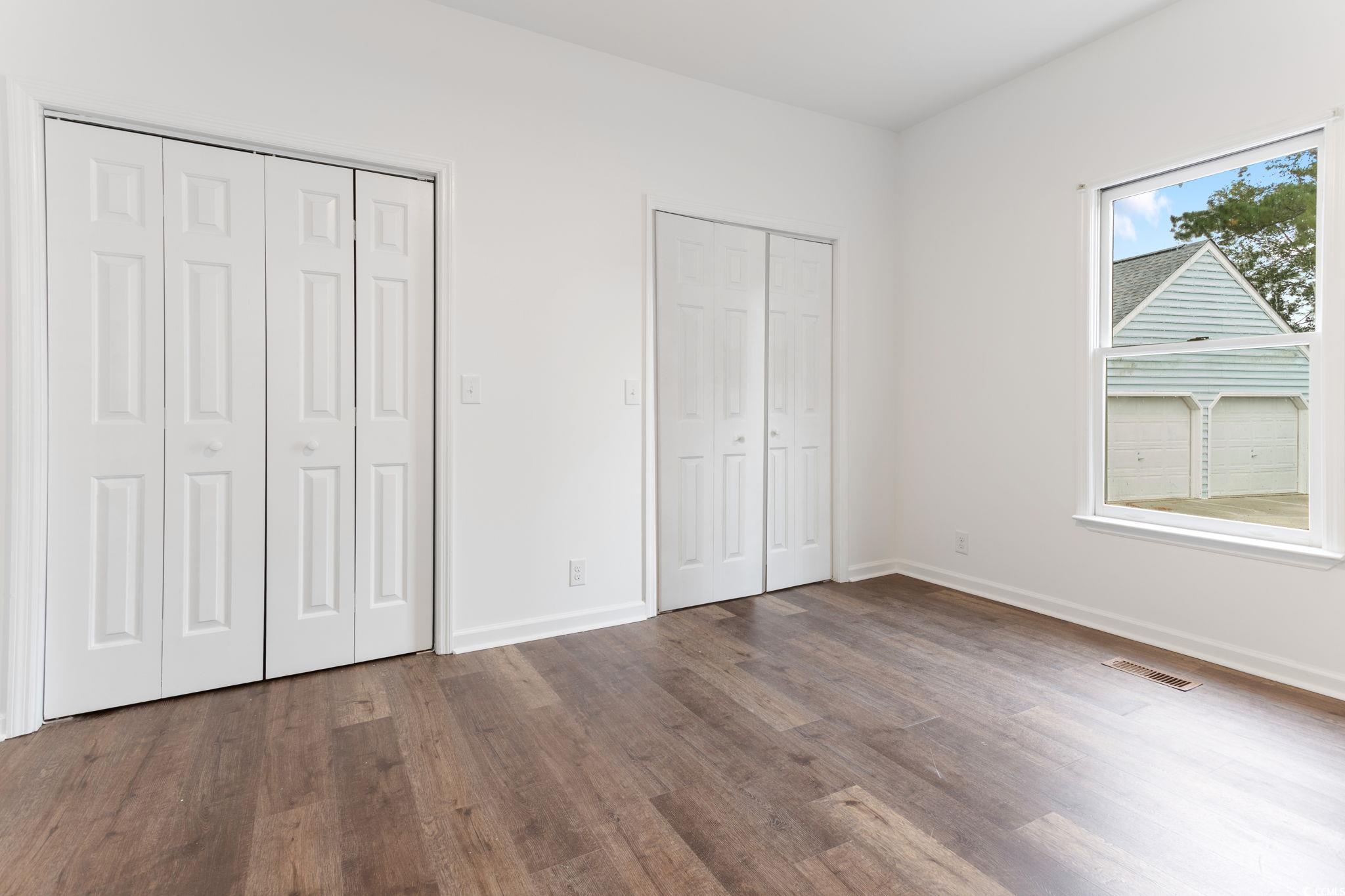 2321 Brick Drive Longs, SC 29568 - Photo 13 of 40 Unfurnished bedroom with two closets and dark wood-style flooring