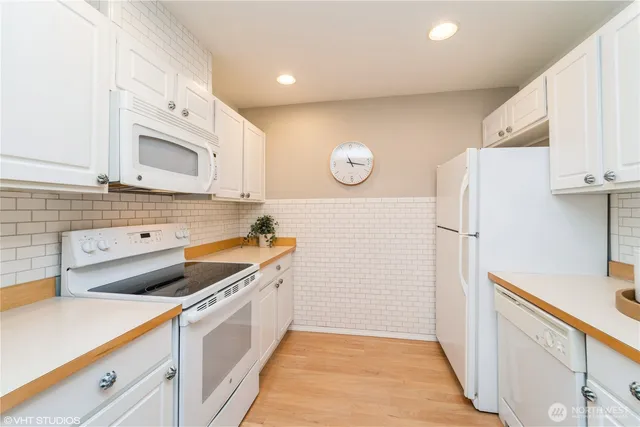 a kitchen with a sink a stove a refrigerator and cabinets