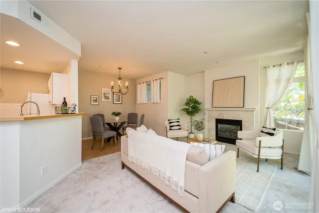 a living room with furniture a fireplace and a large window