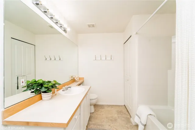 a bathroom with a tub sink and mirror