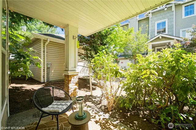 a backyard of a house with table and chairs and potted plants