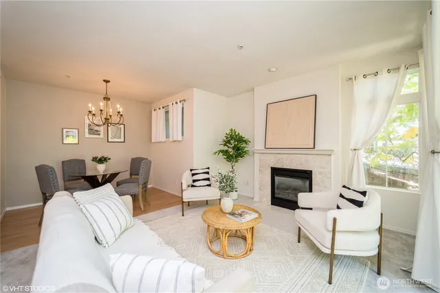 a living room with furniture a fireplace and a large window