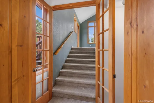 a view of staircase with lots of frames on wall and a window