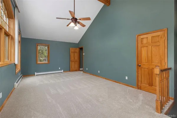 an empty room with windows and fan