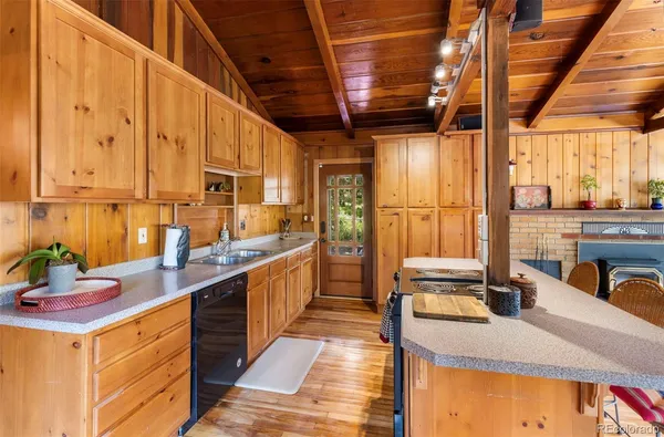 a kitchen with kitchen island granite countertop a sink a counter top space and cabinets