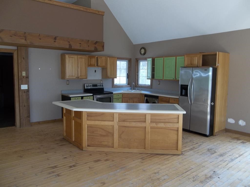8770 North Kilbuck Road Monroe Center, IL 61052 - Photo 12 of 18 a kitchen with stainless steel appliances granite countertop a sink a stove a refrigerator a washer and dryer with wooden floor