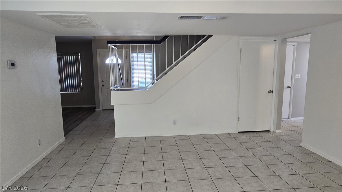3849 Reflection Way Las Vegas, NV 89147 - Photo 7 of 25 This living space features durable tile flooring, leading to a staircase with classic railings.