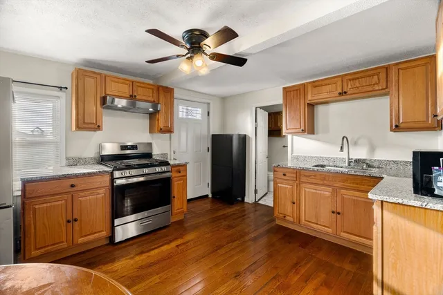 a kitchen with stainless steel appliances granite countertop a stove a sink and a refrigerator