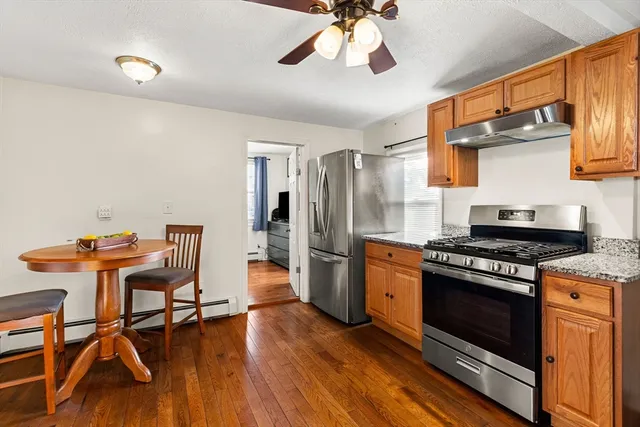 a kitchen with stainless steel appliances a stove a refrigerator and wooden floor
