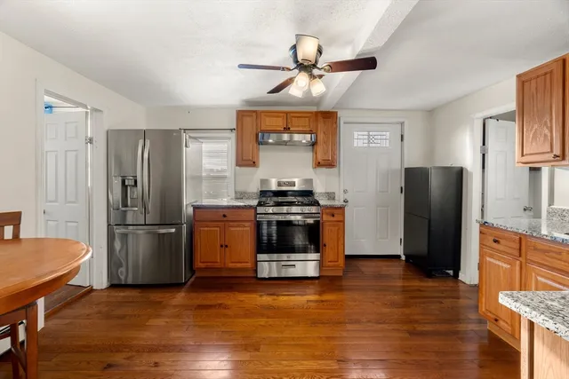 a kitchen with a refrigerator and a stove top oven