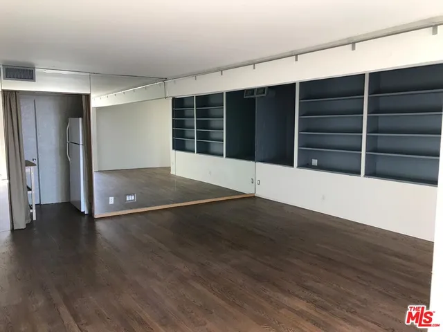 an empty room with wooden floor and window