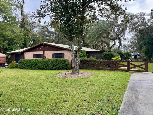 a view of a house with backyard and sitting area
