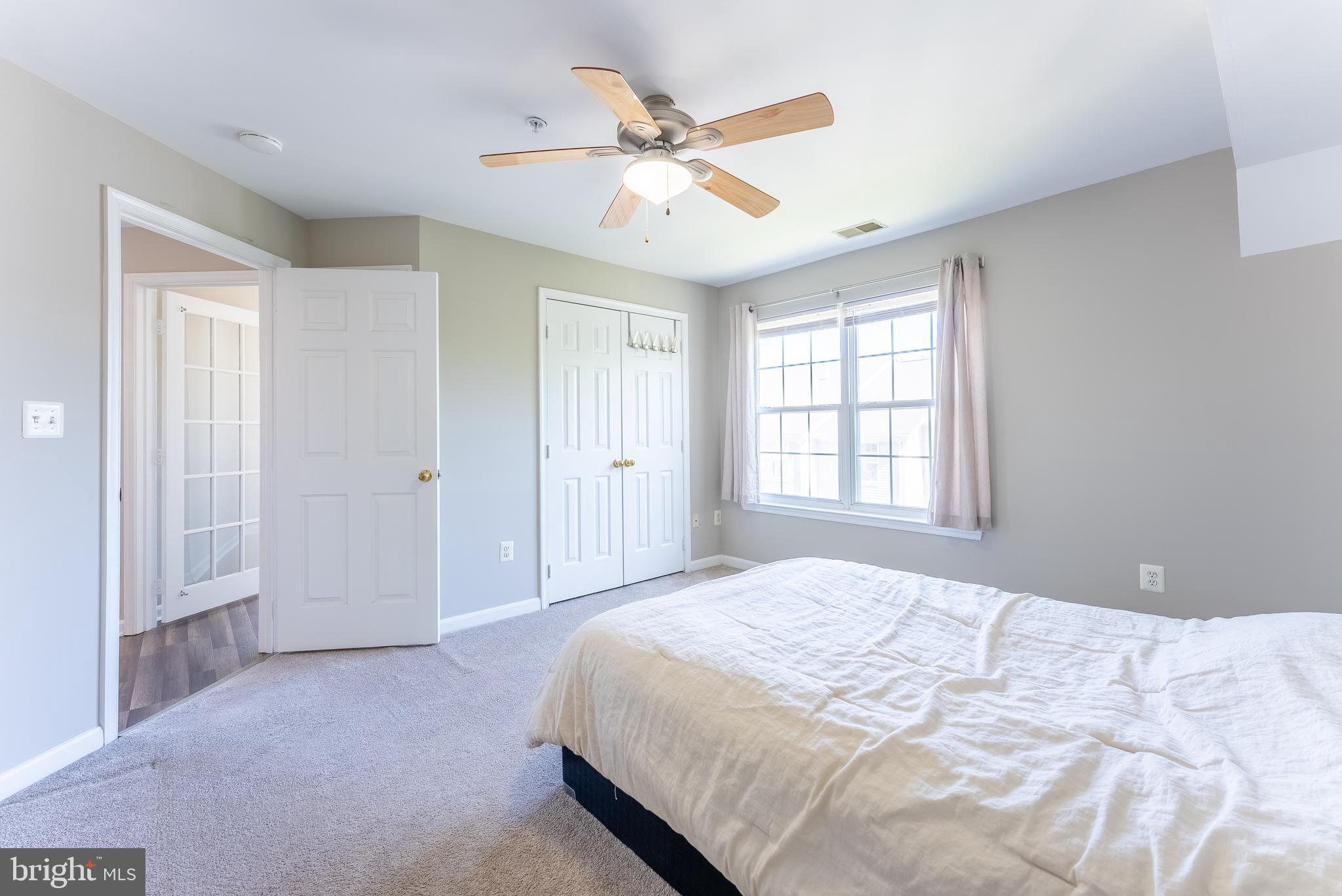 645 Constellation Square Southeast, Unit L Leesburg, VA 20175 - Photo 14 of 44 a spacious bedroom with a large bed and a ceiling fan