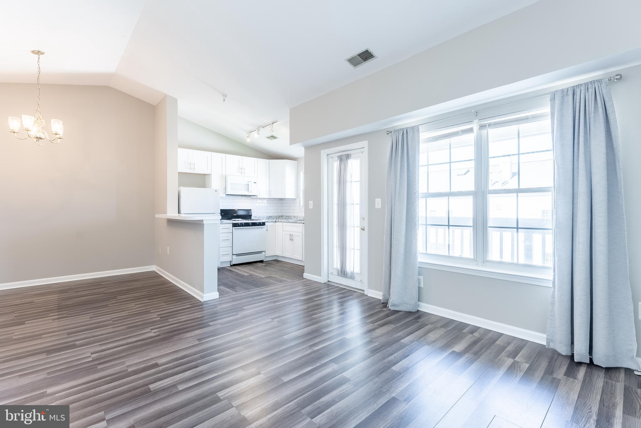 645 Constellation Square Southeast, Unit L Leesburg, VA 20175 - Photo 20 of 44 an empty room with wooden floor a ceiling fan and windows