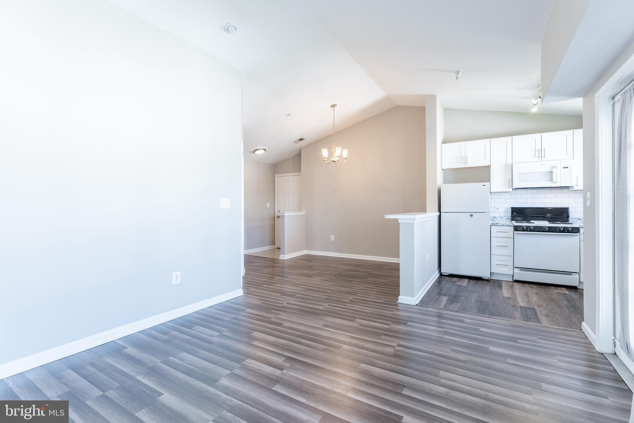 645 Constellation Square Southeast, Unit L Leesburg, VA 20175 - Photo 21 of 44 a view of a kitchen with a fridge and wooden floor
