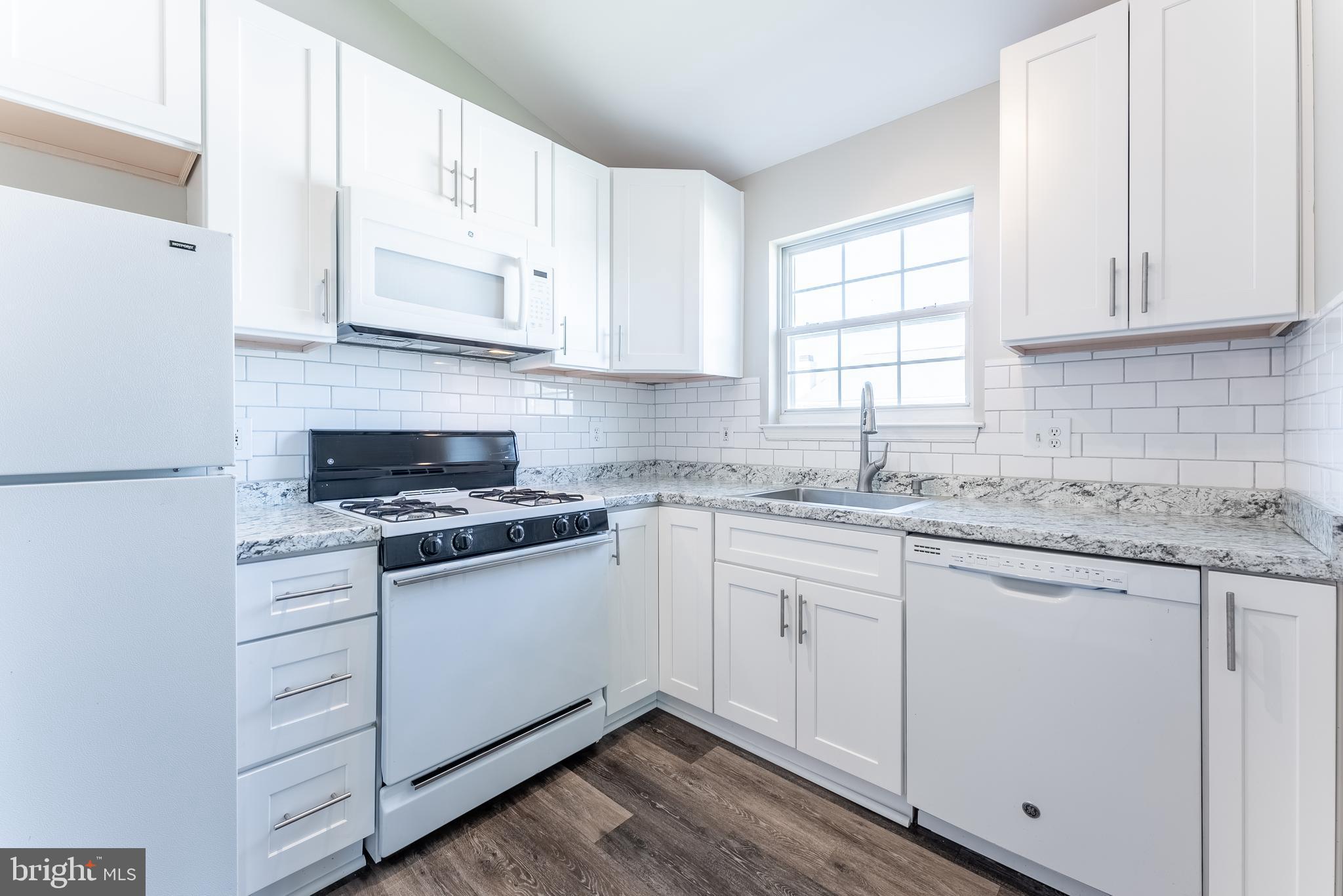 645 Constellation Square Southeast, Unit L Leesburg, VA 20175 - Photo 23 of 44 a kitchen with granite countertop white cabinets and white appliances