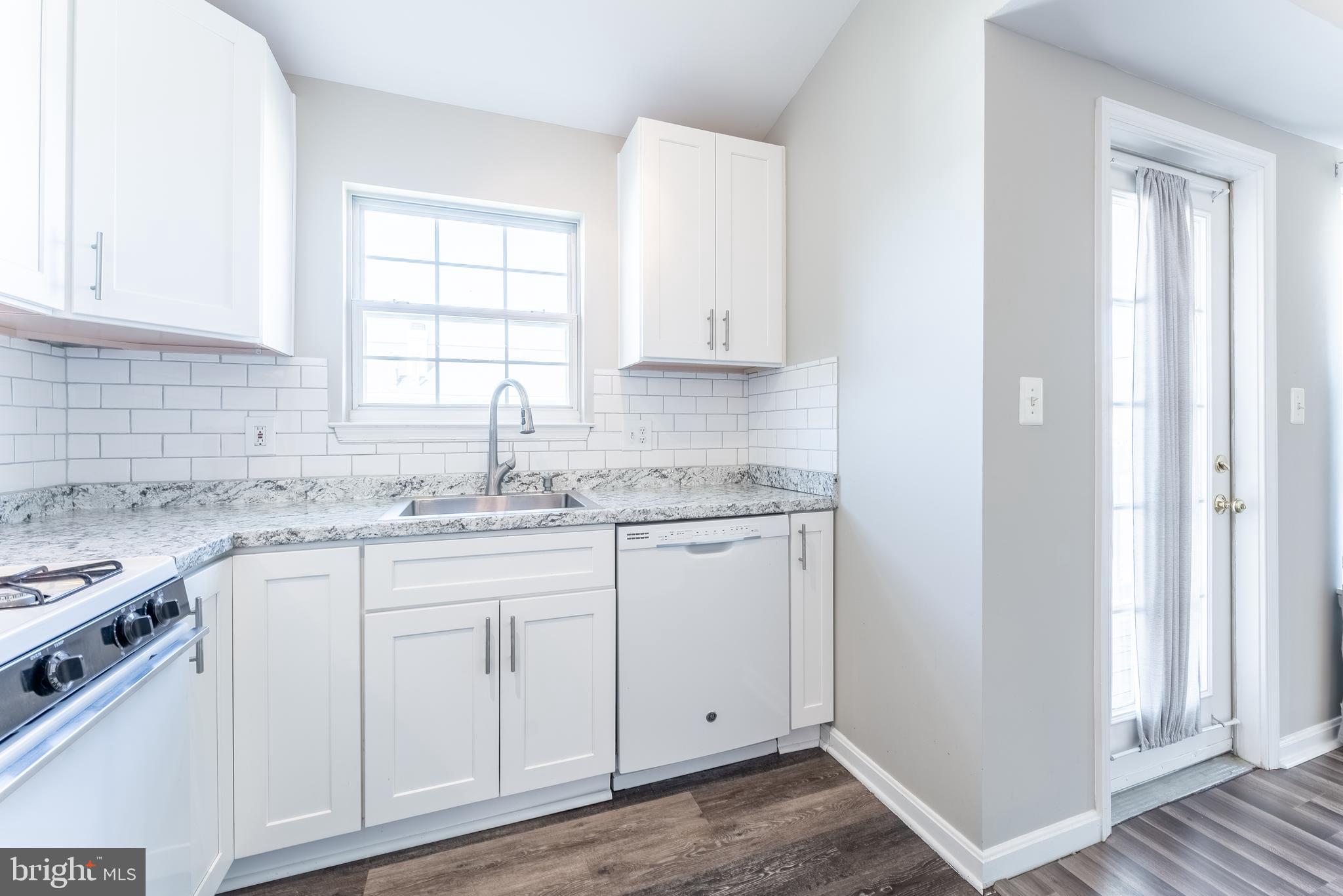 645 Constellation Square Southeast, Unit L Leesburg, VA 20175 - Photo 25 of 44 a kitchen with granite countertop white cabinets and white appliances