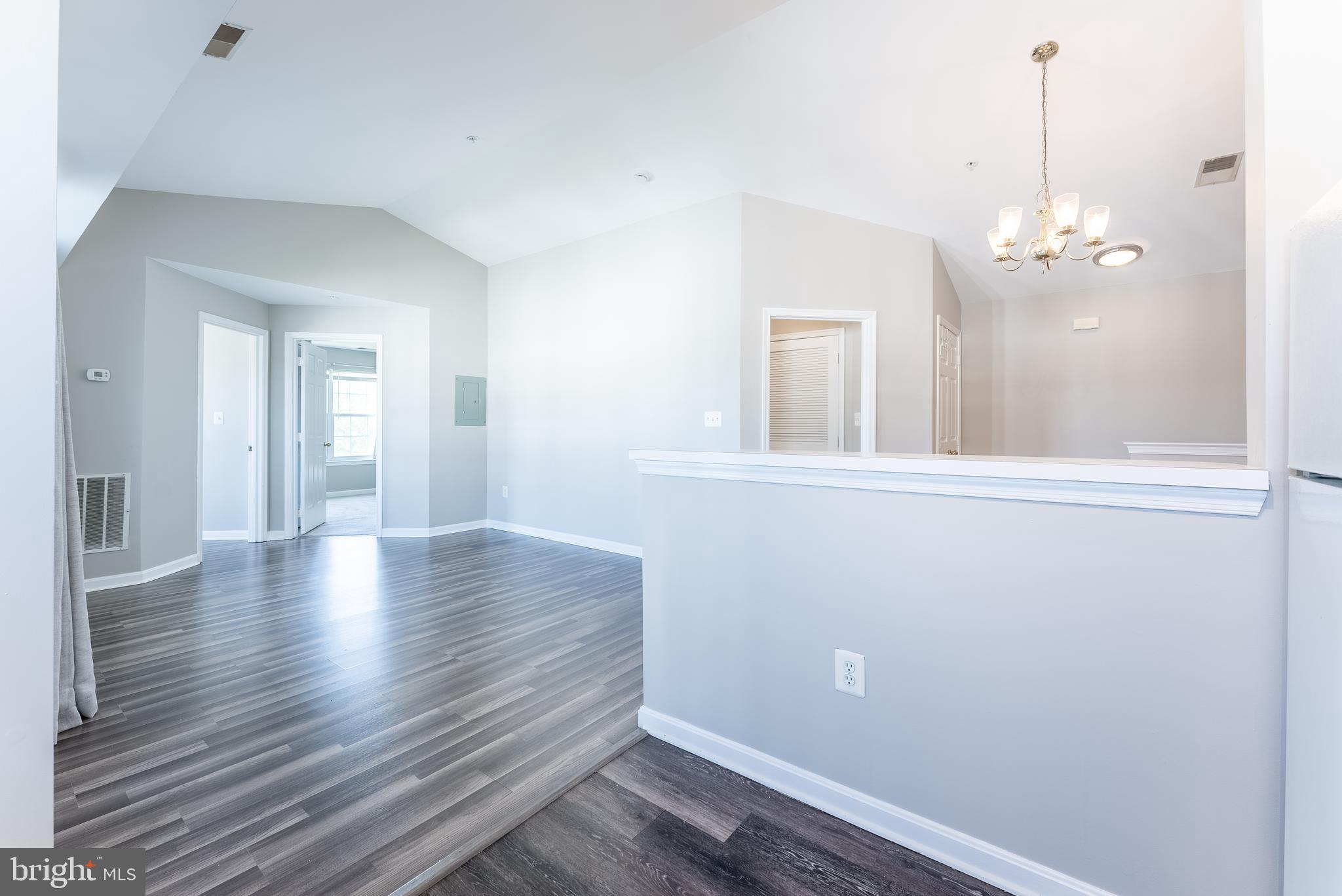 645 Constellation Square Southeast, Unit L Leesburg, VA 20175 - Photo 26 of 44 a view of a hallway with wooden floor and a chandelier