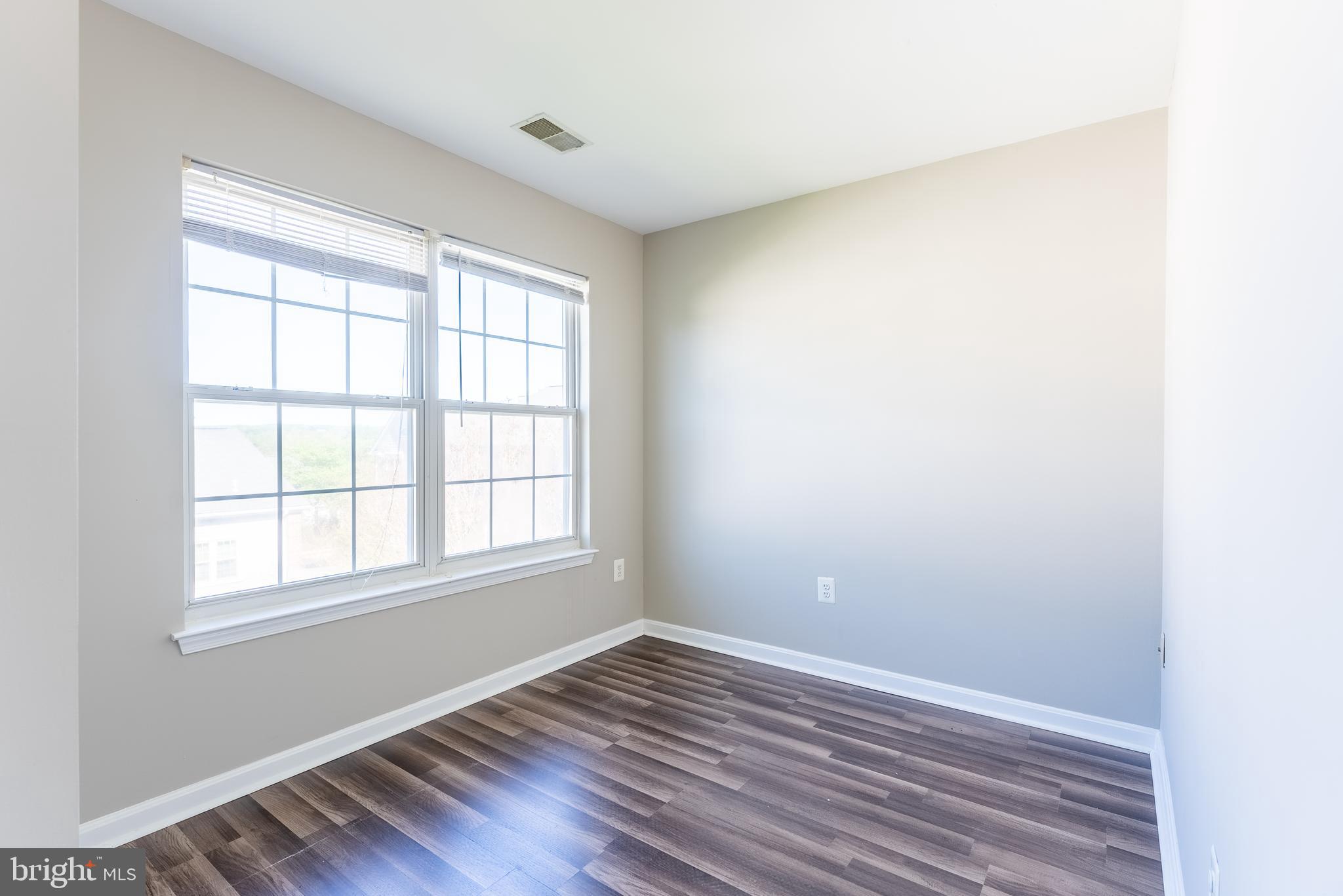 645 Constellation Square Southeast, Unit L Leesburg, VA 20175 - Photo 9 of 44 an empty room with wooden floor and windows
