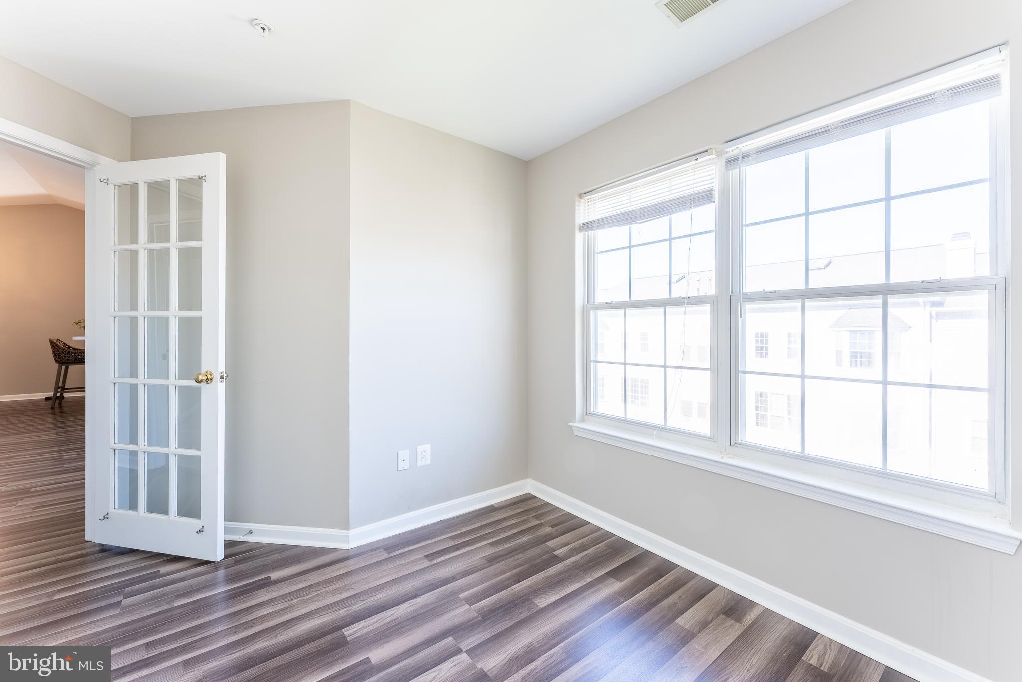 645 Constellation Square Southeast, Unit L Leesburg, VA 20175 - Photo 10 of 44 a view of an empty room with wooden floor and a window