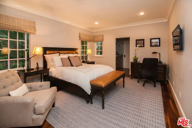 a spacious bedroom with a bed a couch and a potted plant