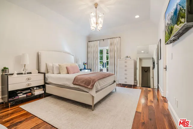 a spacious bedroom with a bed and a chandelier