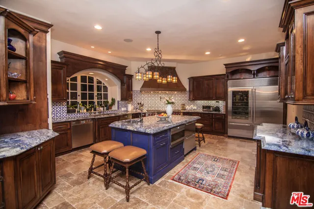 a kitchen with granite countertop a stove refrigerator and dining table