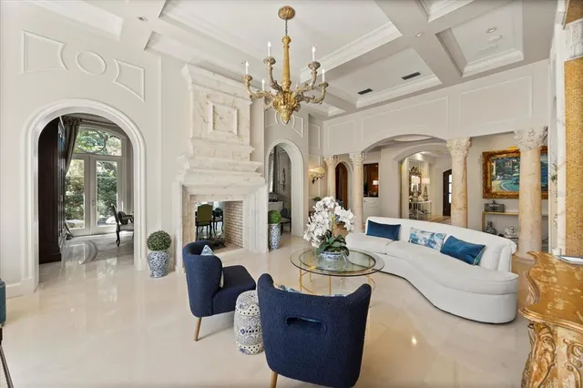 a living room with furniture a fireplace and a chandelier