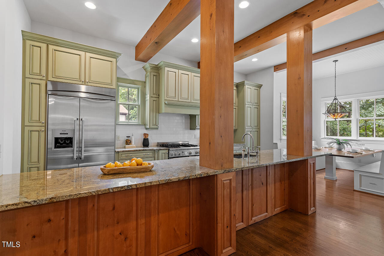 2000 Greyhawk Place Apex, NC 27539 - Photo 21 of 59 a kitchen with stainless steel appliances granite countertop a sink a stove and wooden floors