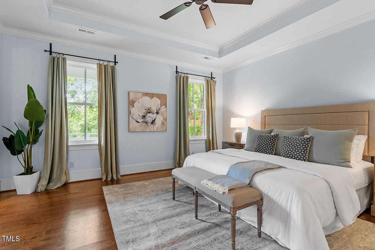 2000 Greyhawk Place Apex, NC 27539 - Photo 29 of 59 a bedroom with a large bed and a chandelier