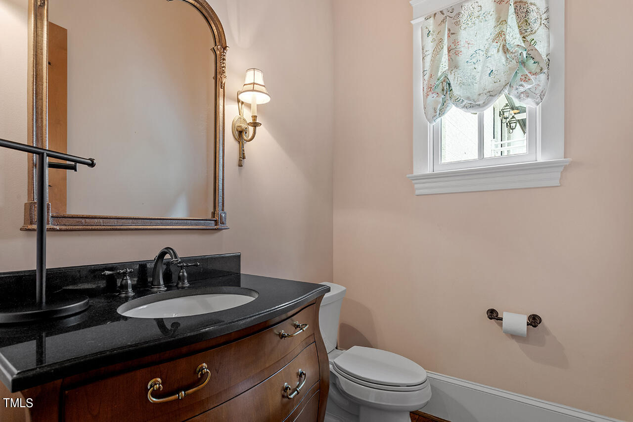 2000 Greyhawk Place Apex, NC 27539 - Photo 35 of 59 a bathroom with a granite countertop sink a toilet and a mirror