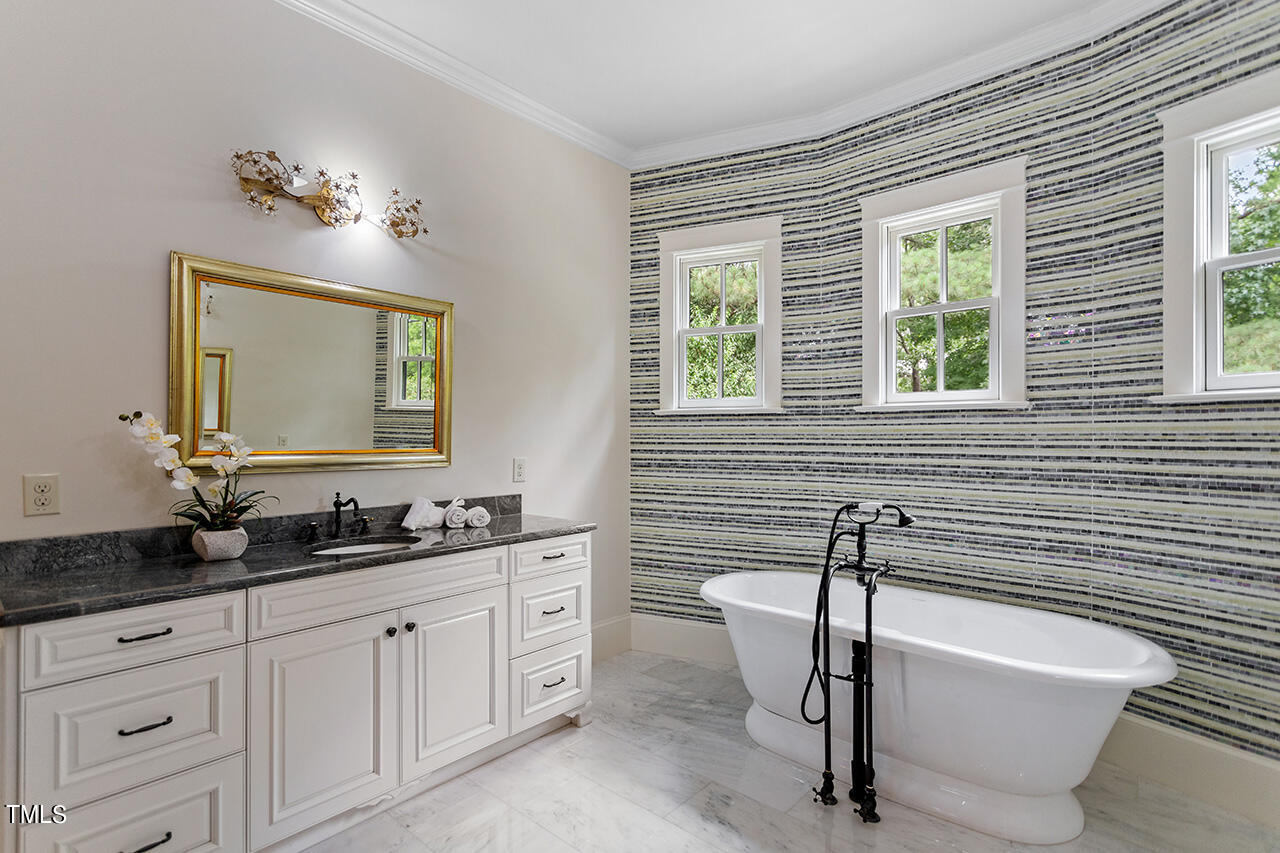 2000 Greyhawk Place Apex, NC 27539 - Photo 38 of 59 a bathroom with a double vanity sink a mirror and a bathtub