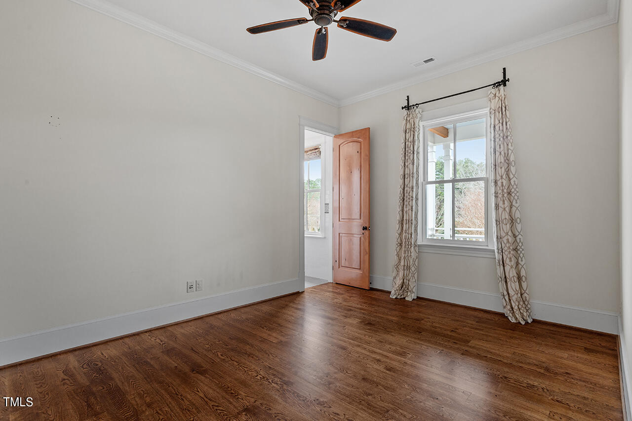 2000 Greyhawk Place Apex, NC 27539 - Photo 46 of 59 an empty room with wooden floor fan and windows